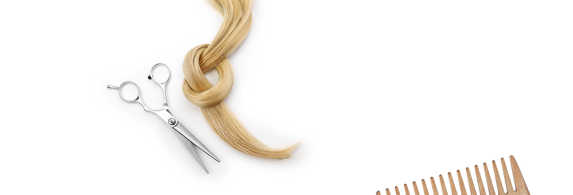 Scissors, a comb, and a strand of hair on the work top